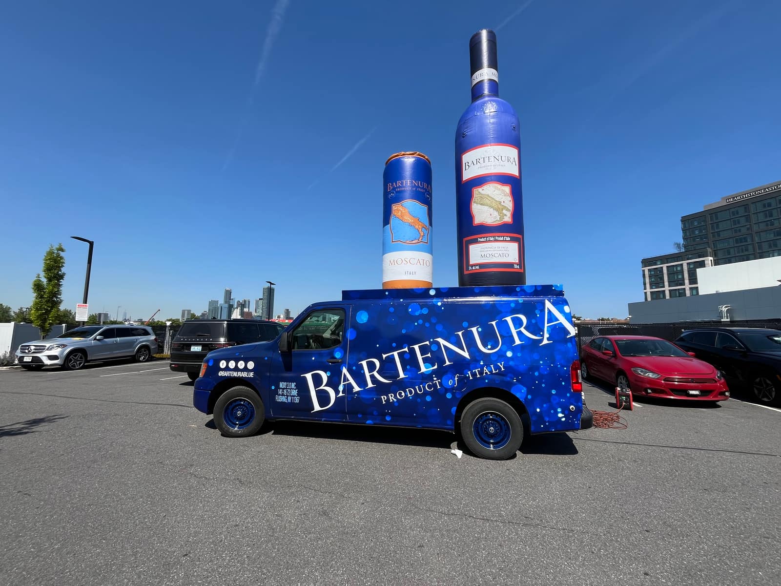 Bartenura-wrapped van beside a giant inflatable bottle at a brand activation