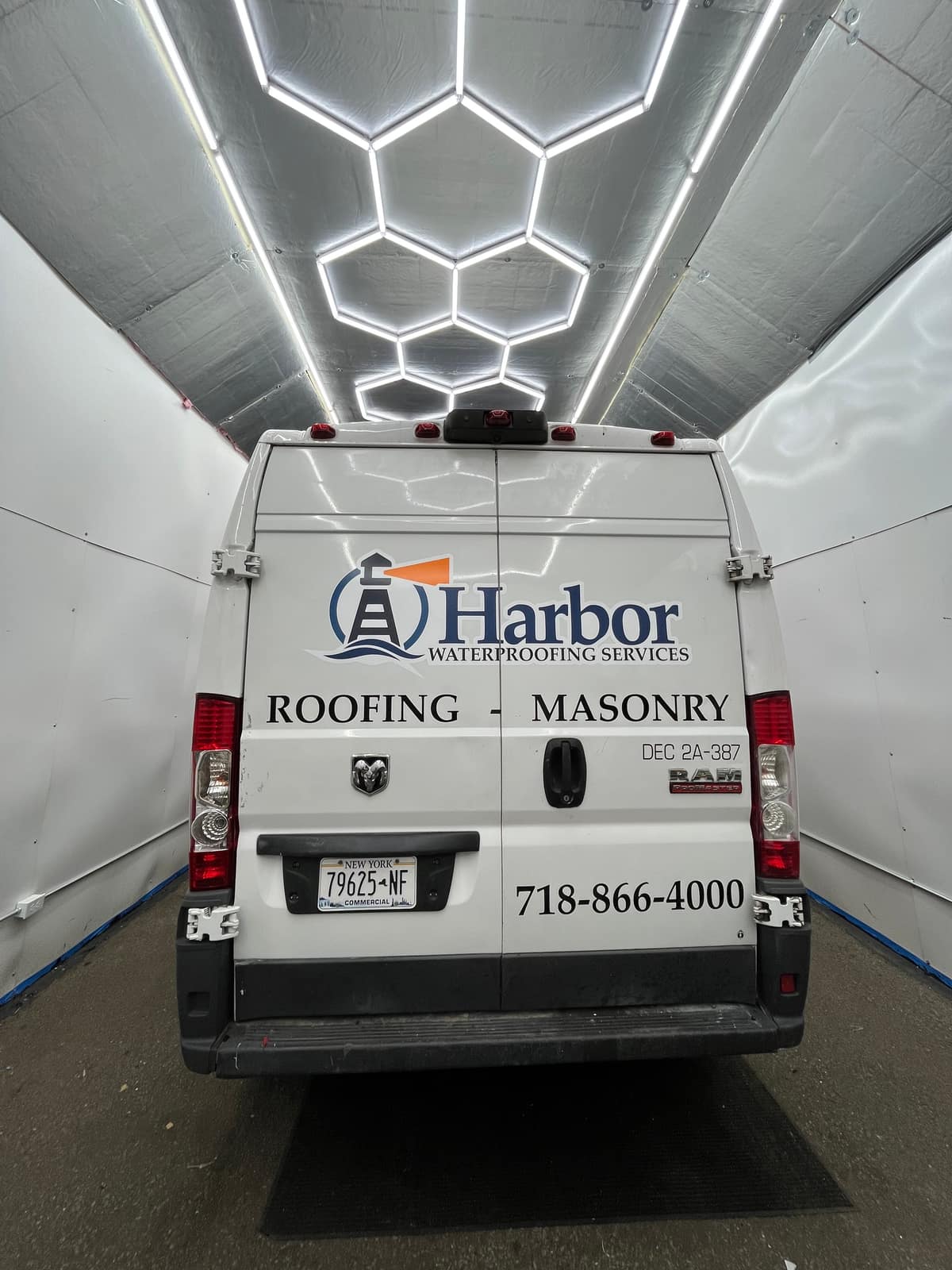 Rear doors of a white Ram ProMaster with the Harbor Waterproofing logo, the words Roofing and Masonry, and a phone number