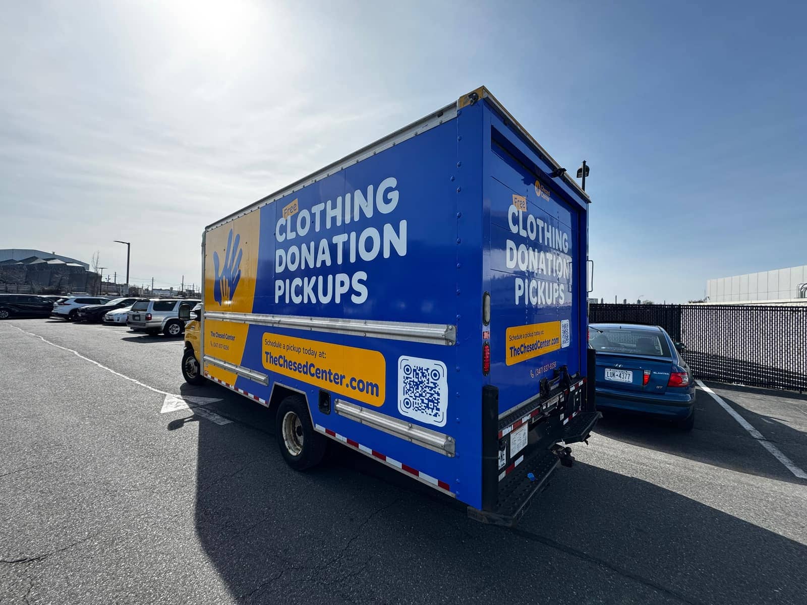 Full wrap on a box truck for The Chesed Center's free clothing donation pickups, designed, printed and installed by NYC Car Wraps