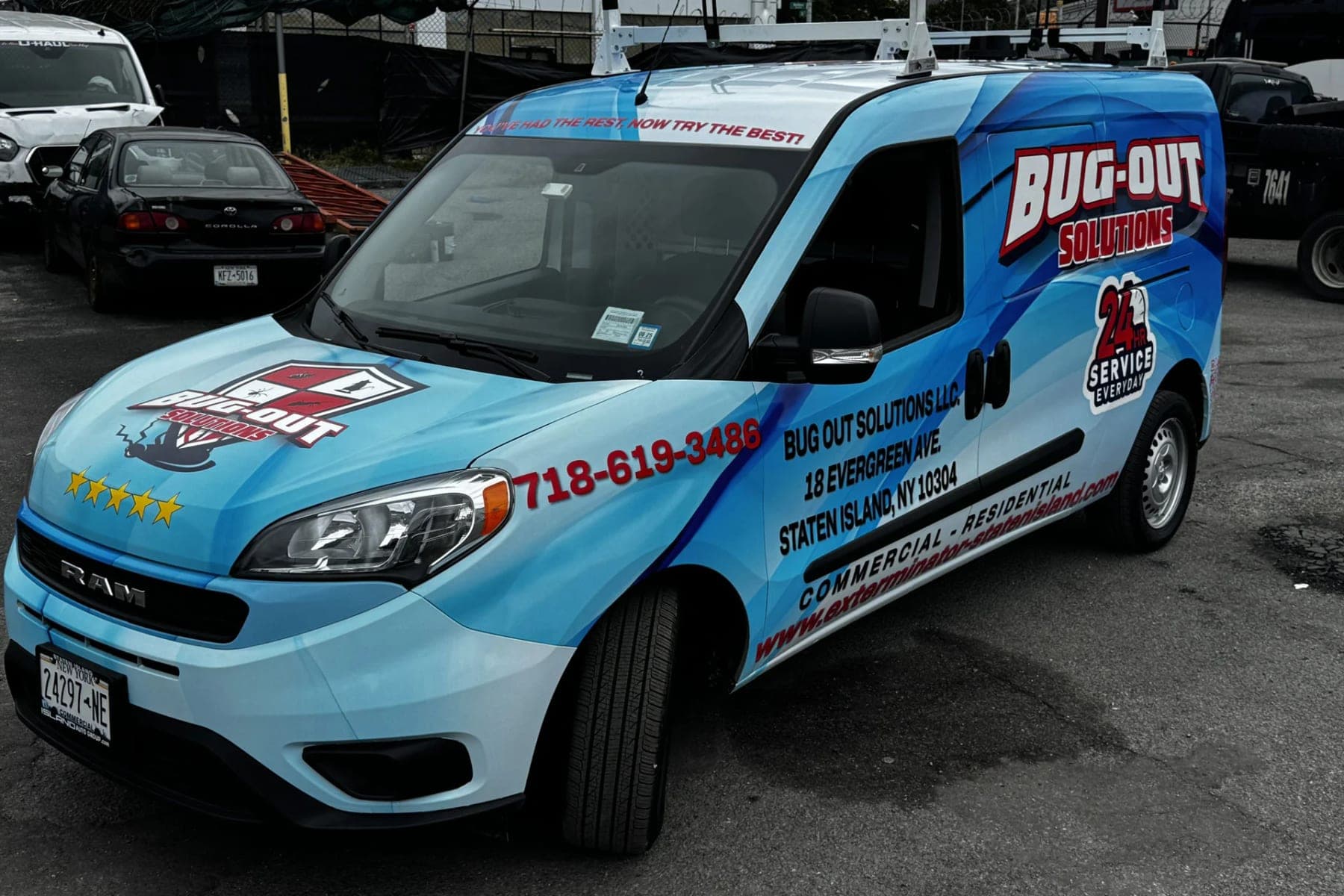 Front three-quarter view of the Bug-Out Solutions Ram ProMaster City, showing the hood logo, phone number on the fender and Staten Island address on the door