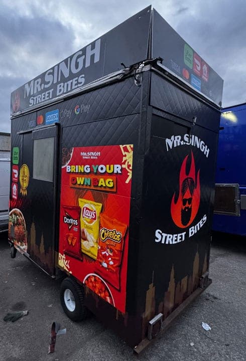 Rear three-quarter view of the wrapped Mr. Singh Street Bites cart in a parking lot