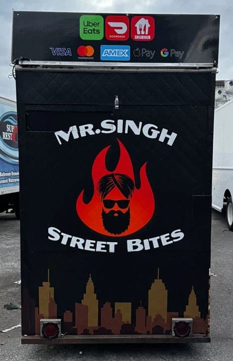 Rear of the Mr. Singh Street Bites cart with the red flame logo and skyline band