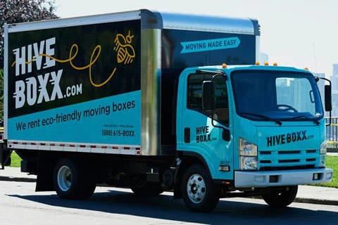 HiveBoxx Isuzu box truck with a teal cab and printed box graphic, side view