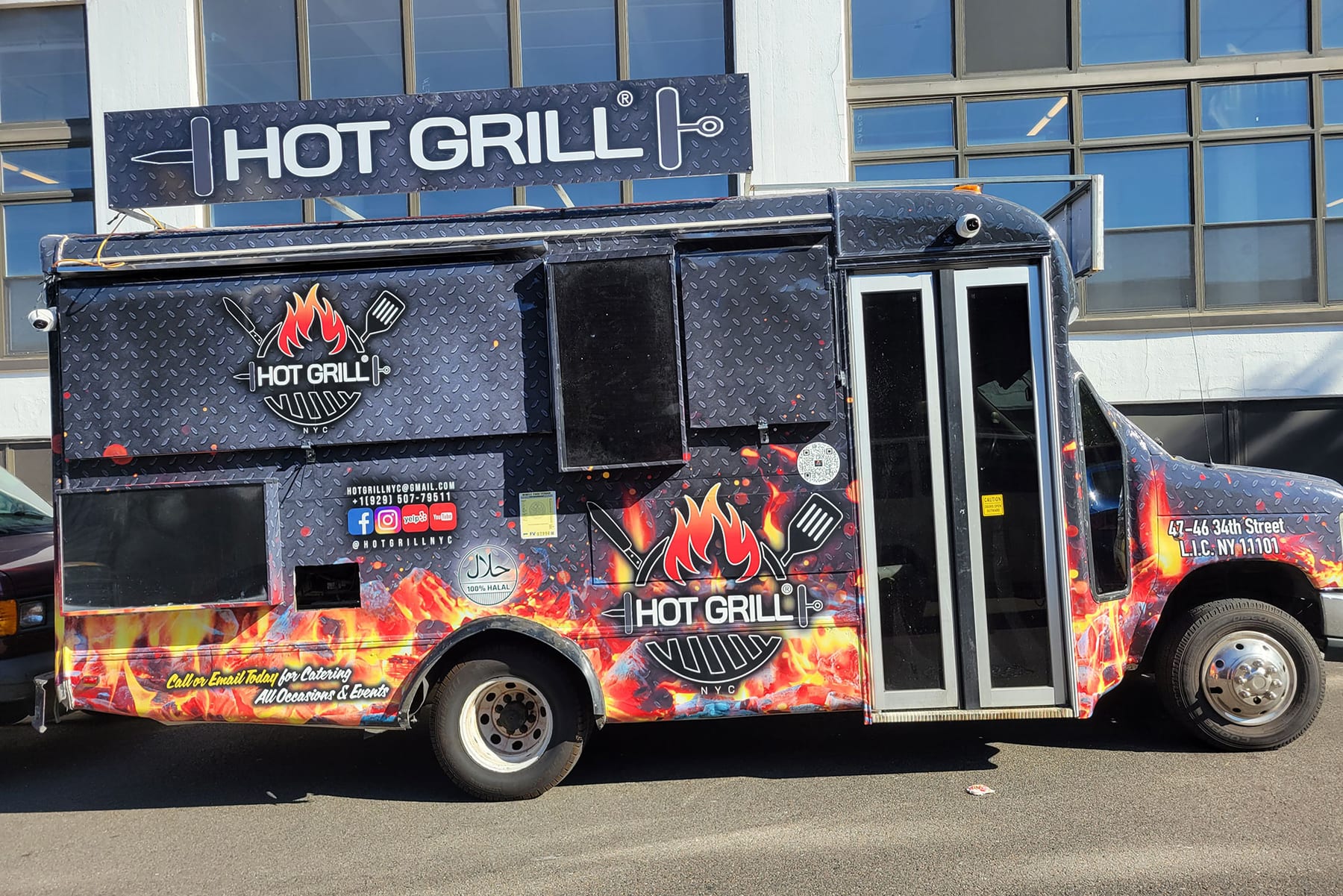 Hot Grill shawarma truck with a full black wrap, flame graphics and printed menu, side view