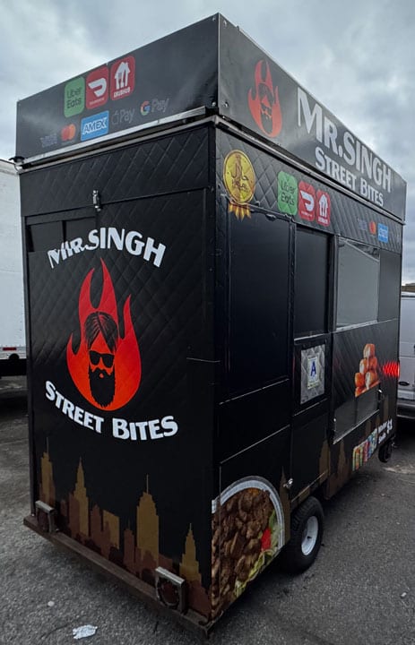 Mr. Singh Street Bites black food cart with red logo, skyline graphic and chip and food photos, side view