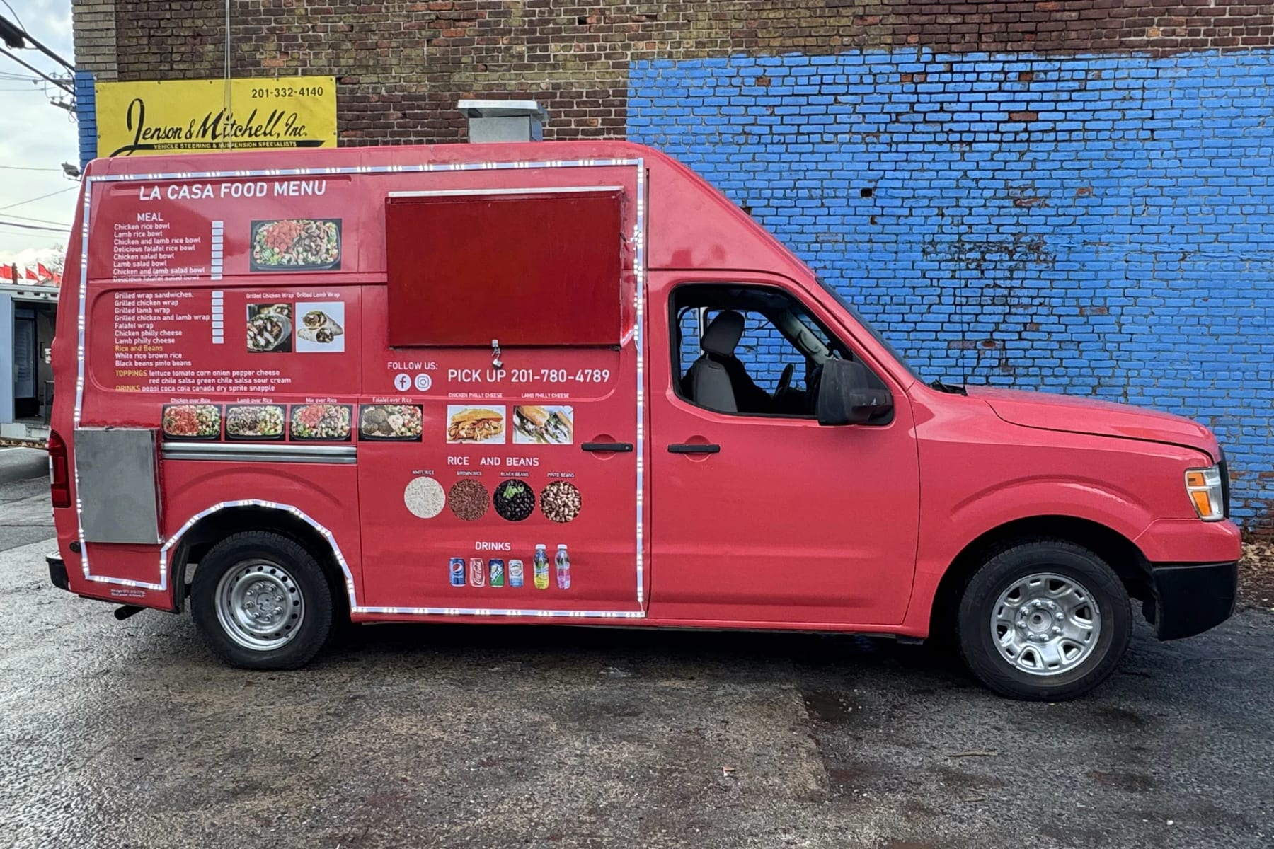 Red Nissan NV food van with a partial wrap: cab left in factory red, printed menu panel and serving window added on the side